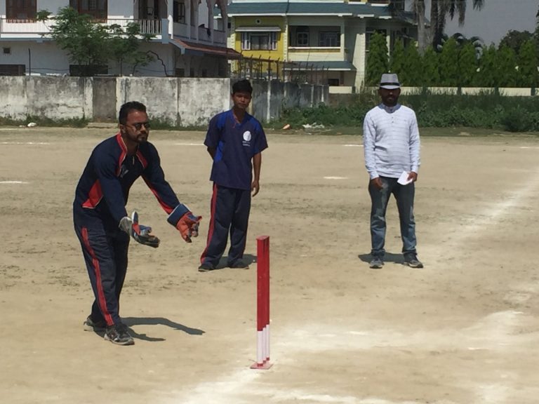 A person is trying to hit a ball with a cricket bat during the game.