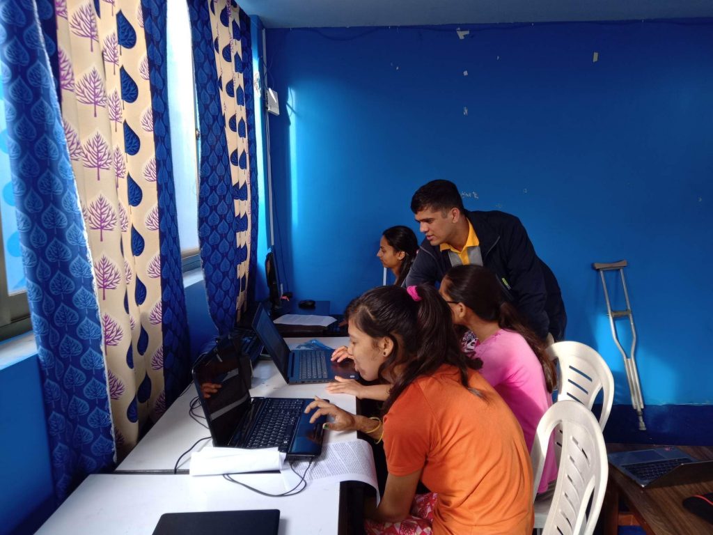 computer trainers teaching the young women with disabilities.