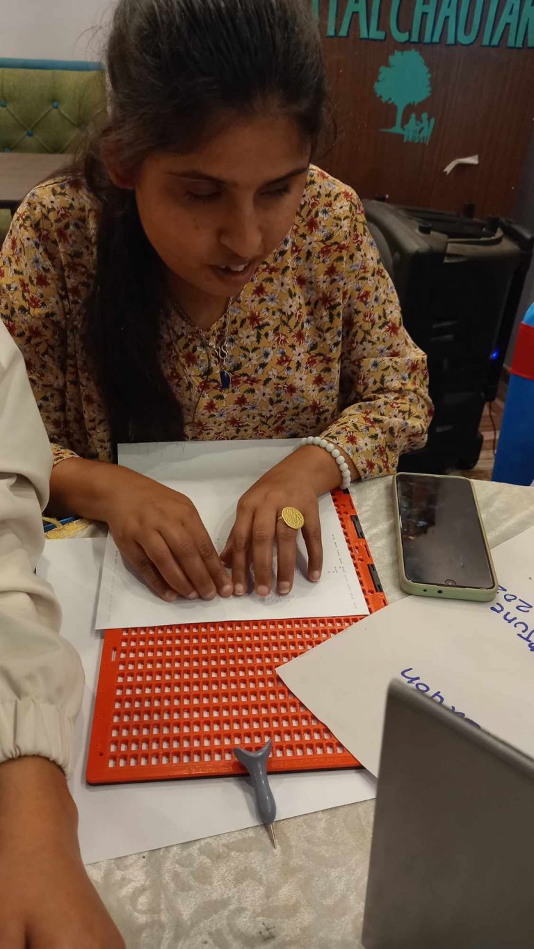 Visually impaired participants preparing material in Braille