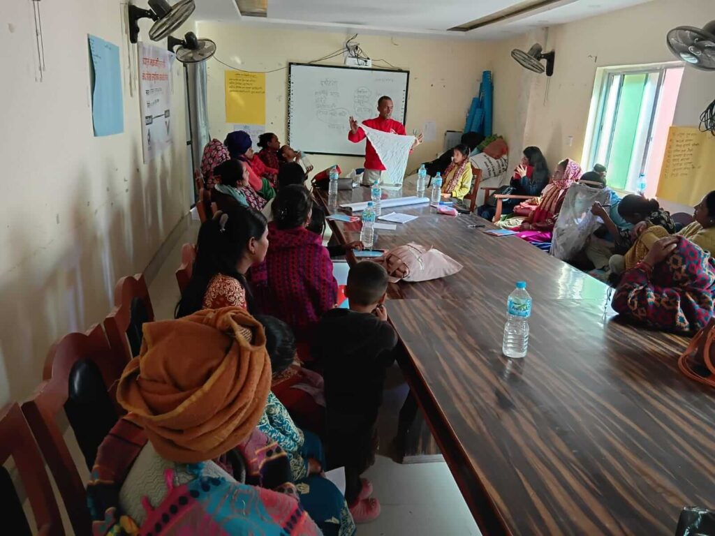 Trainer Shiva Ram Khatri is facilitating the training, demonstrating how to use white cotton cloth while cleaning or dressing a wound, as the participants observe attentively.